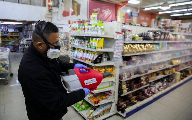Workers disinfect the Bar Kol Supermarket in Safed, March 16, 2020, as part of measures to prevent the spread of the coronavirus. (David Cohen/Flash90) Workers disinfect the Bar Kol Supermarket in Safed, March 16, 2020, as part of measures to prevent the spread of the coronavirus. (David Cohen/Flash90)