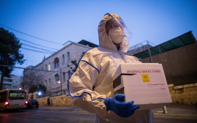 A Magen David Adom worker arrives to test a patient with symptoms of COVID-19, in Jerusalem on March 16, 2020. (Yonatan Sindel/Flash90) A Magen David Adom worker arrives to test a patient with symptoms of COVID-19, in Jerusalem on March 16, 2020. (Yonatan Sindel/Flash90)