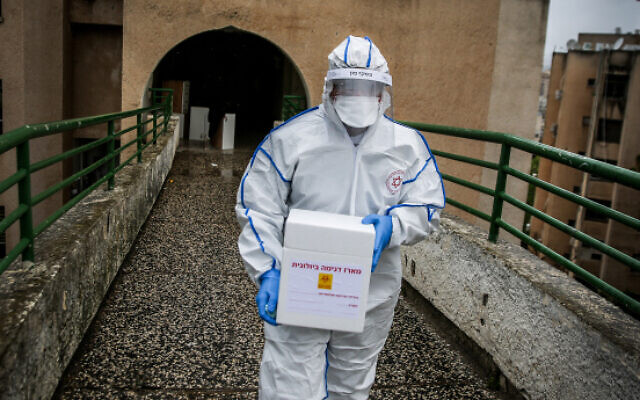 A Magen David Adom worker wears protective clothing as he arrives to test a patient with symptoms of COVID-19 in the northern Israeli city of Safed, March 17, 2020 (David Cohen/Flash90) A Magen David Adom worker wears protective clothing as he arrives to test a patient with symptoms of COVID-19 in the northern Israeli city of Safed, March 17, 2020 (David Cohen/Flash90)
