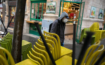 An Israeli wearing a face mask walks in the city center of Jerusalem on March 17, 2020. (Olivier Fitoussi/Flash90)
