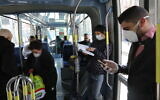 Israelis wearing face mask for fear of the coronavirus are seen in public transport in Jerusalem on March 17, 2020. (Yossi Zamir/Flash90)