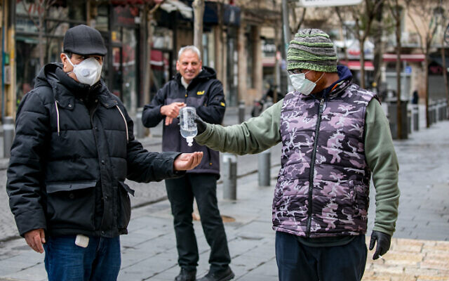A merchant selling hand sanitizer to passersby in central Jerusalem on March 18, 2020. (Olivier Fitoussi/Flash90) A merchant selling hand sanitizer to passersby in central Jerusalem on March 18, 2020. (Olivier Fitoussi/Flash90)
