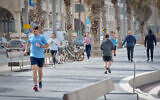 People run near the beach in Tel Aviv on March 19, 2020 (Avshalom Sassoni/Flash90)