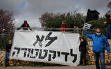 Protesters rail against Knesset speaker Yuli Edelstein's decision to prohibit meetings of the Knesset plenum, carrying a sign reading 'No to dictatorship' outside the Knesset in Jerusalem, March 19, 2020 (Yonatan Sindel/Flash90)