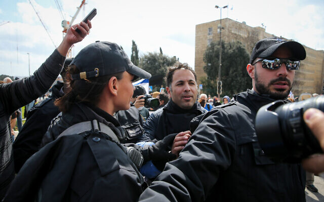 Protesters scuffle with police during a demonstration "to save Israel's democracy" following far-reaching government actions against the coronavirus, outside the Knesset in Jerusalem, March 19, 2019. (Yonatan Sindel/Flash90) Protesters scuffle with police during a demonstration "to save Israel's democracy" following far-reaching government actions against the coronavirus, outside the Knesset in Jerusalem, March 19, 2019. (Yonatan Sindel/Flash90)