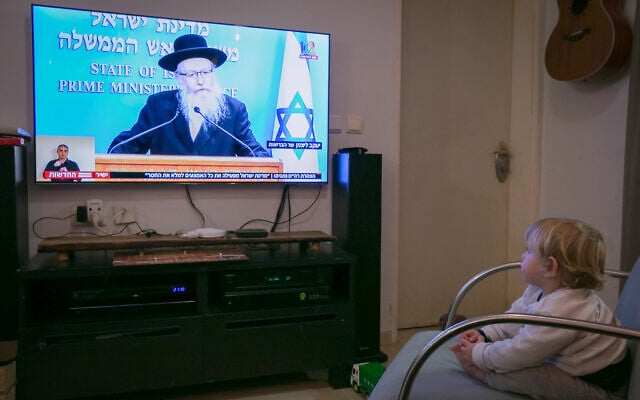 An Israeli child watch as Health Minister Yaakov Litzman holds a live press conference on the new government restrictions for the public regarding the coronavirus on March 19, 2020. (Chen Leopold/Flash90) An Israeli child watch as Health Minister Yaakov Litzman holds a live press conference on the new government restrictions for the public regarding the coronavirus on March 19, 2020. (Chen Leopold/Flash90)