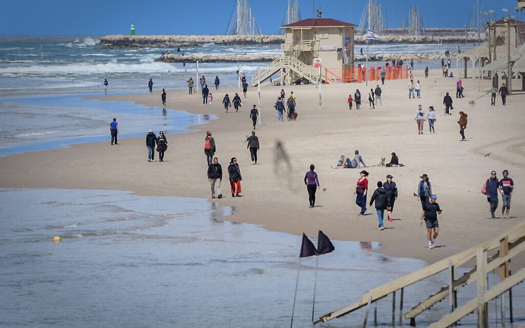 Israelis visit the beach in Tel Aviv despite government orders to avoid public gatherings due to the spread of the new coronavirus, March 21, 2020. (Avshalom Sassoni/Flash90) Israelis visit the beach in Tel Aviv despite government orders to avoid public gatherings due to the spread of the new coronavirus, March 21, 2020. (Avshalom Sassoni/Flash90)