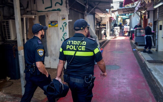 Israeli police officers close shops following the government decision, at the Carmel market in Tel Aviv on March 22, 2020. (Avshalom Sassoni/Flash90) Israeli police officers close shops following the government decision, at the Carmel market in Tel Aviv on March 22, 2020. (Avshalom Sassoni/Flash90)