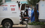 Ambulance workers transfer a woman with suspected COVID-19 at Hadassah Ein Kerem hospital, in Jerusalem, on March 22, 2020. (Flash90)