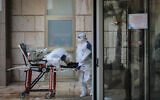 Illustrative: Magen David Adom workers transferring a woman at Hadassah Ein Karem hospital, in Jerusalem, on March 22, 2020. (Flash90)