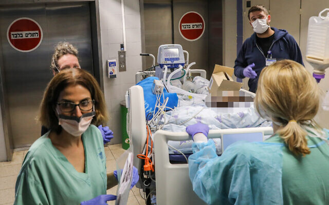 Illustrative: Staff and Ichilov hospital in Tel Aviv move a patient to a new ward, March 22, 2020. (Yossi Zamir/Flash90) Illustrative: Staff and Ichilov hospital in Tel Aviv move a patient to a new ward, March 22, 2020. (Yossi Zamir/Flash90)