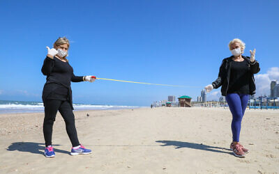 Israelis visit the beach in Rishon Lezion on March 22, 2020. (Yossi Zamir/Flash90)