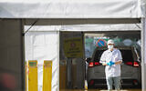 A Magen David Adom worker is seen at a drive-through coronavirus testing facility in Jerusalem on March 24, 2020. (Olivier Fitoussi/Flash90)