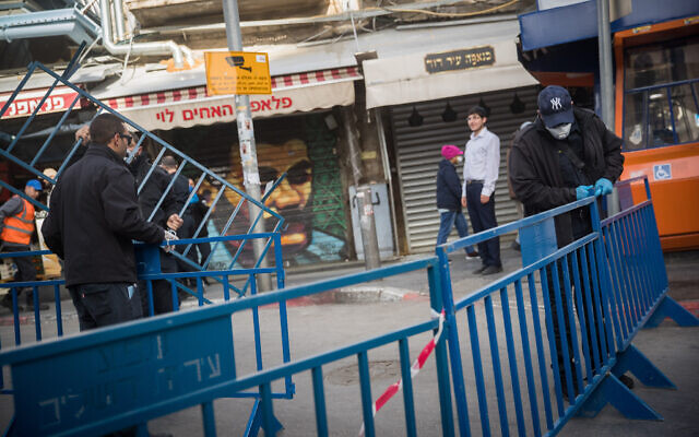 Jerusalem Municipality workers close the entrances to the Mahane Yehuda market in Jerusalem on March 24, 2020 (Yonatan Sindel/Flash90) Jerusalem Municipality workers close the entrances to the Mahane Yehuda market in Jerusalem on March 24, 2020 (Yonatan Sindel/Flash90)
