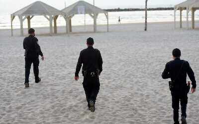 Police patrol on the Tel Aviv beach boardwalk on March 25, 2020. (Avshalom Sassoni/Flash90)