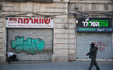 A man passes shuttered stores on Jaffa Street in Jerusalem on March 25, 2020 (Yonatan Sindel/Flash90)