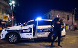 Israeli police officers stand guard in the Geula neighborhood in Jerusalem on March 25, 2020, as they arrive to close shops in the area following a state order. (Yonatan Sindel/Flash90)