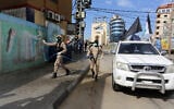Members of the Palestinian Islamic Jihad terror group's armed wing, the Al-Quds Brigades, spray disinfectant in the streets of Rafah in the southern Gaza Strip, during a campaign aimed at slowing down the spread of the novel coronavirus, March 26, 2020. (Abed Rahim Khatib/Flash90)