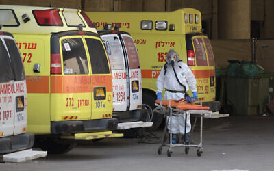 Illustrative: An Israeli medical team member is cleaning and disinfecting an ambulance at Tel Aviv’s Dan Panorama hotel which was turned into quarantine facility in Tel Aviv, on March 26, 2020. (Gili Yaari /Flash90)