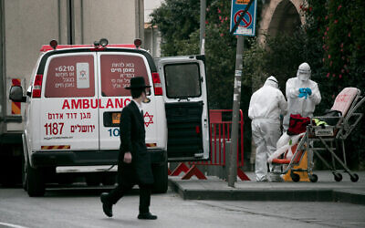 Magen David Adom paramedics in protective clothing are seen in Jerusalem on March 28, 2020. (Olivier Fitoussi/Flash90)