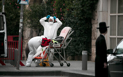 Magen David Adom paramedics in protective clothing are seen in Jerusalem on March 28, 2020. (Olivier Fitoussi/Flash90)