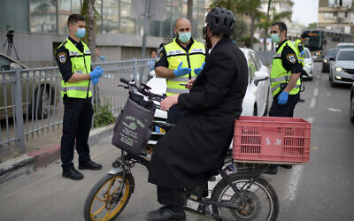 Police officers man a checkpoint at an entrance to the predominantly ultra-Orthodox city of Bnei Brak, which has seen a large number of coronavirus cases, on March 31, 2020. (Gili Yaari/Flash90)