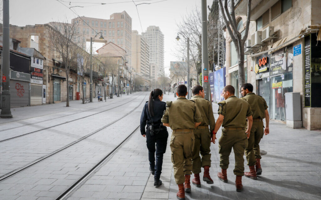 A police officer walks with soldiers as they patrol Jerusalem city center to enforce a partial lockdown against the spread of the coronavirus on March 31, 2020. (Olivier Fitoussi/Flash90) A police officer walks with soldiers as they patrol Jerusalem city center to enforce a partial lockdown against the spread of the coronavirus on March 31, 2020. (Olivier Fitoussi/Flash90)