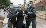 ILLUSTRATIVE: Police officers detain a man in Beit Shemesh while enforcing social distancing rules on March 31, 2020. (Yaakov Lederman/Flash90)