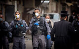Police officers close synagogues and disperse public gatherings in Jerusalem's Mea Shearim as part of efforts to contain the coronavirus, March 31, 2020. (Yonatan Sindel/Flash90)