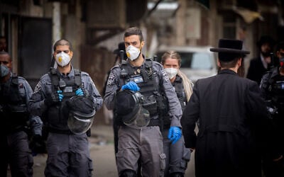 Police officers close synagogues and disperse public gatherings in Jerusalem's Mea Shearim as part of efforts to contain the coronavirus, March 31, 2020. (Yonatan Sindel/Flash90)