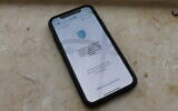 An iPhone running the Health Ministry's HaMagen app, which aims to track the spread of the novel coronavirus and warn users if they have interacted with someone infected. (Sam Sokol)