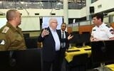 President Reuven Rivlin inaugurates the new national emergency call center jointly run by Magen David Adom (MDA) and the IDF Homefront Command in Ramle as part of the efforts to deal with the coronavirus. At right is Eli Bin, CEO of MDA  and left is the IDF Homefront Command's Maj Gen Tamir Yadai. (Mark Neyman)