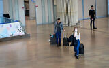 People wearing face masks for fear of the coronavirus arrive at Ben Gurion International Airport near Tel Aviv, March 10, 2020. (Avshalom Sassoni/Flash90)