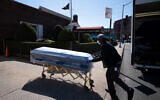 A worker delivers caskets to the Gerard Neufeld Funeral Home in the Queens borough of New York City, March 27, 2020. (AP/Mark Lennihan)
