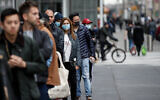New Yorkers wait in line outside a Whole Foods supermarket in Manhattan, March 20, 2020. (AP/John Minchillo)