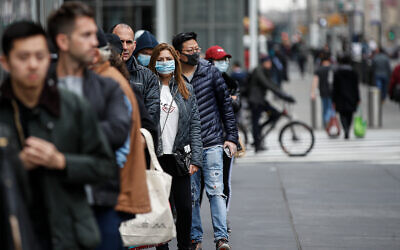 New Yorkers wait in line outside a Whole Foods supermarket in Manhattan, March 20, 2020. (AP/John Minchillo)