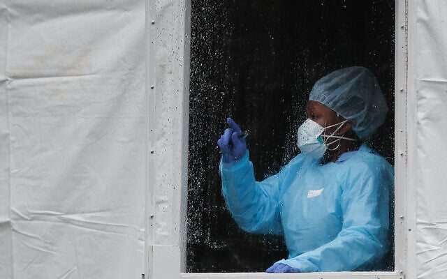 A medical worker gestures at a COVID-19 testing station at The Brooklyn Hospital Center, March 23, 2020, in New York. (AP Photo/John Minchillo) A medical worker gestures at a COVID-19 testing station at The Brooklyn Hospital Center, March 23, 2020, in New York. (AP Photo/John Minchillo)