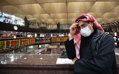 A Kuwaiti trader wearing a protective mask follows the market at the Boursa Kuwait stock exchange in Kuwait City, March 1, 2020. (Yasser al-Zayyat/AFP)