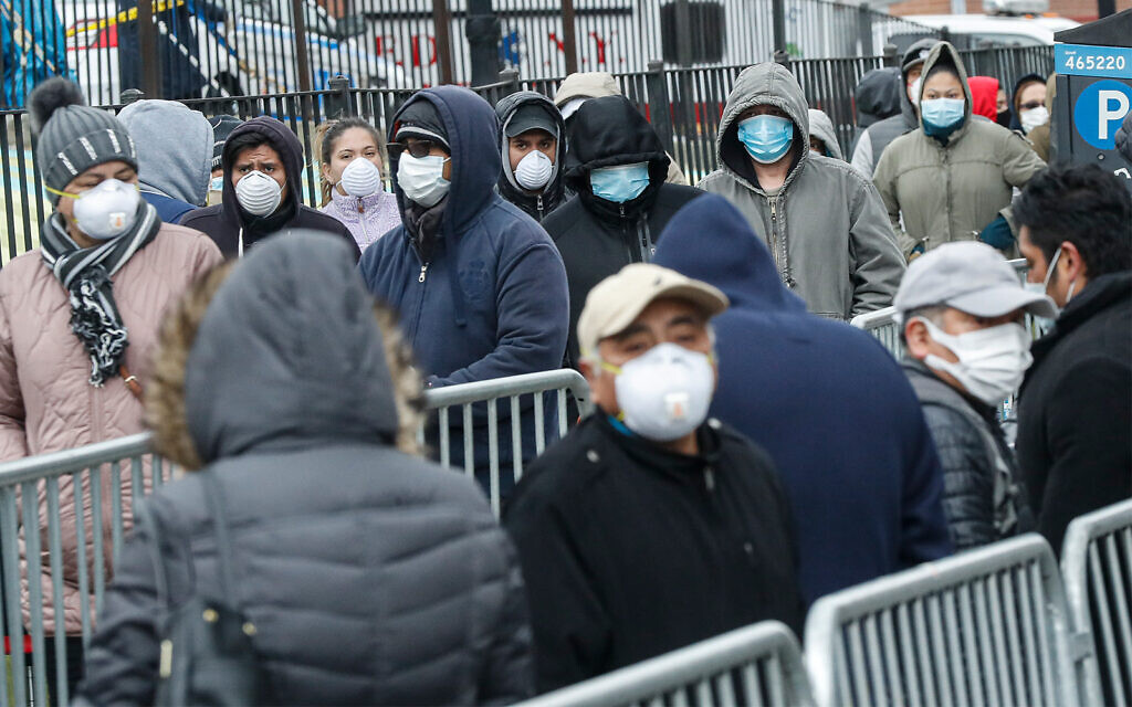 Patients wear personal protective equipment while maintaining social distancing as they wait in line for a COVID-19 test at Elmhurst Hospital Center in New York, March 25, 2020. (AP/John Minchillo) Patients wear personal protective equipment while maintaining social distancing as they wait in line for a COVID-19 test at Elmhurst Hospital Center in New York, March 25, 2020. (AP/John Minchillo)