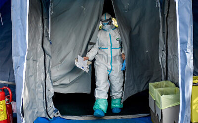 Medical personnel leave one of the emergency structures that were set up to ease procedures outside the hospital of Brescia, Northern Italy, March 10, 2020. (Claudio Furlan/LaPresse via AP)