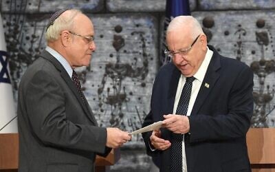 Central Elections Committee chairman Supreme Court Justice Neal Hendel, left, hands the official results of the elections to the 23rd Knesset to President Reuven Rivlin, at the President's House, March 11, 2020. (Mark Neyman/GPO)