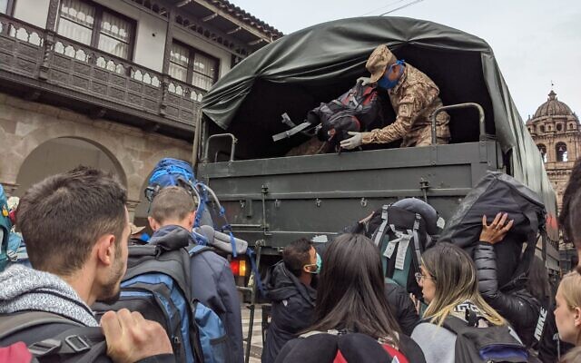 A Peruvian soldier unloads the bags of Israeli travelers at the airport in Peru's southeastern city of Cusco, March, 19, 2020. (Amsalem Tours) A Peruvian soldier unloads the bags of Israeli travelers at the airport in Peru's southeastern city of Cusco, March, 19, 2020. (Amsalem Tours)