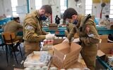 Israeli troops pack boxes of food as part of the military's preparations to support the country's supply lines in light of the coronavirus pandemic in March 2020. (Israel Defense Forces)