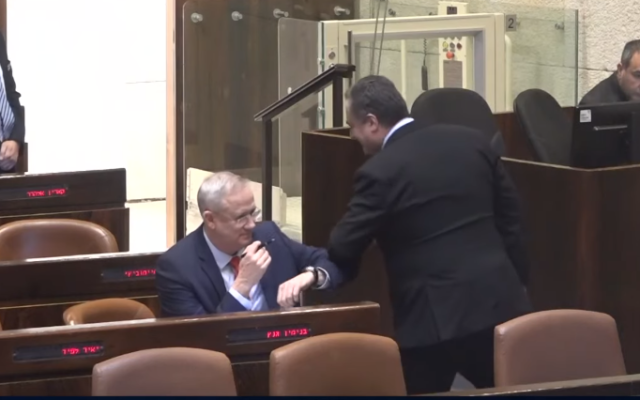 Benny Gantz (L) and Foreign Minister Israel Katz of Likud exchange an elbow bump in lieu of a handshake at the Knesset on March 26, 2020, during the vote on Gantz's election as Knesset speaker (video screenshot) Benny Gantz (L) and Foreign Minister Israel Katz of Likud exchange an elbow bump in lieu of a handshake at the Knesset on March 26, 2020, during the vote on Gantz's election as Knesset speaker (video screenshot)