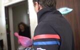 A volunteer delivers a package of meals to an elderly resident of Tel Aviv, March 22, 2020. (Oded Karni, Government Press Office)