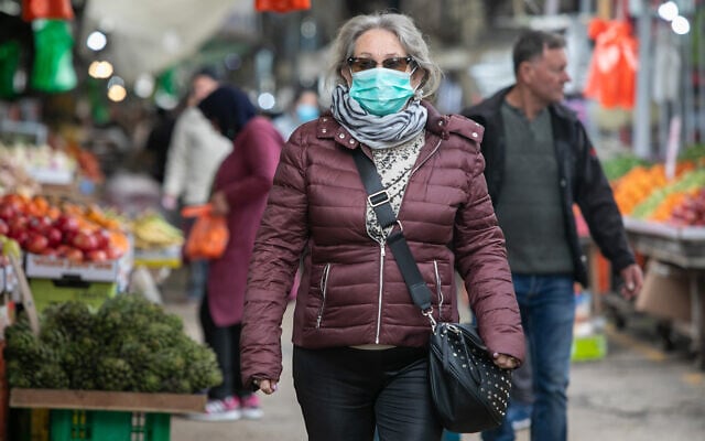 An Israeli woman wears a face mask for fear of the coronavirus while shopping in Ramle, March 19, 2020. (Yossi Aloni/Flash90) An Israeli woman wears a face mask for fear of the coronavirus while shopping in Ramle, March 19, 2020. (Yossi Aloni/Flash90)
