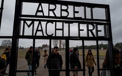 Visitors walk past the gate, inscribed with the words: 'Arbeit Macht Frei' (Work makes you free) of the former Sachsenhausen concentration camp, now a memorial, in Oranienburg, Germany, February 7, 2020. (John MACDOUGALL/AFP)