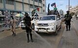 Members of the Palestinian Islamic Jihad terror group's armed wing, the Al-Quds Brigades, spray disinfectant in the streets of Rafah in the southern Gaza Strip on March 26, 2020. (Said Khatib/AFP)