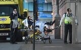 Illustrative: Volunteers from the Hatzola ambulance service, wearing gloves and masks to protect against the coronavirus, wheel a patient into Royal London Hospital in London on March 29, 2020. (Daniel Leal-Olivas/AFP)
