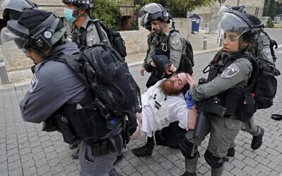 Police arrest an ultra-Orthodox man as they close a synagogue in the Mea Shearim neighborhood in Jerusalem for violating emergency directives to contain the coronavirus, on March 30, 2020. (Ahmad Gharabli/AFP)